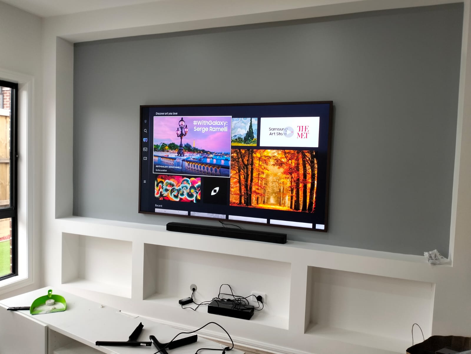 ome entertainment system featuring a wall-mounted TV and soundbar.