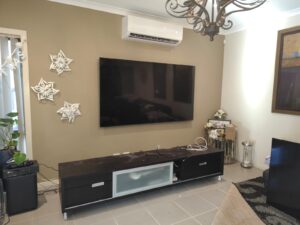 Wall-mounted TV setup with a sleek entertainment unit in a modern living room